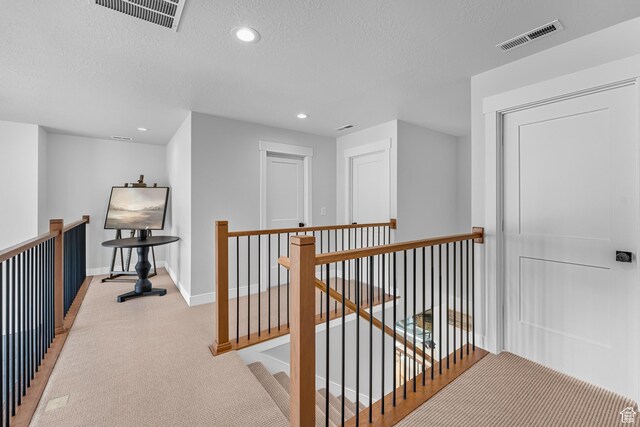 6957 W Farnsworth Peak Dr S Unit 314, West Jordan, UT 84081 - hall featuring an upstairs landing, light colored carpet, a textured ceiling, and recessed lighting