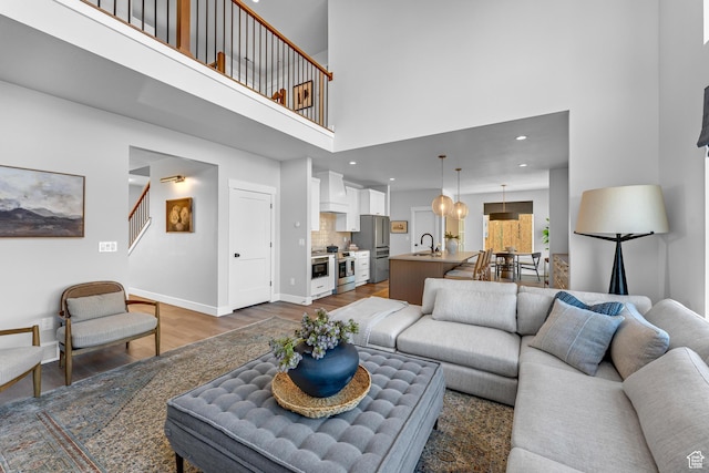 6957 W Farnsworth Peak Dr S Unit 314, West Jordan, UT 84081 - living area with wood finished floors, a high ceiling, stairs, and recessed lighting