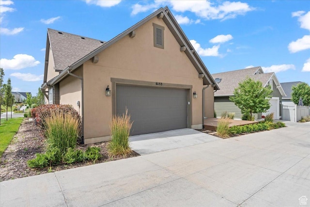 6153 W Poplar View Dr, South Jordan, UT 84009 - view of front facade featuring a garage, concrete driveway, and stucco siding