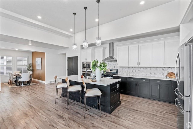 6153 W Poplar View Dr, South Jordan, UT 84009 - kitchen featuring wall chimney range hood, appliances with stainless steel finishes, light countertops, a kitchen bar, and decorative backsplash