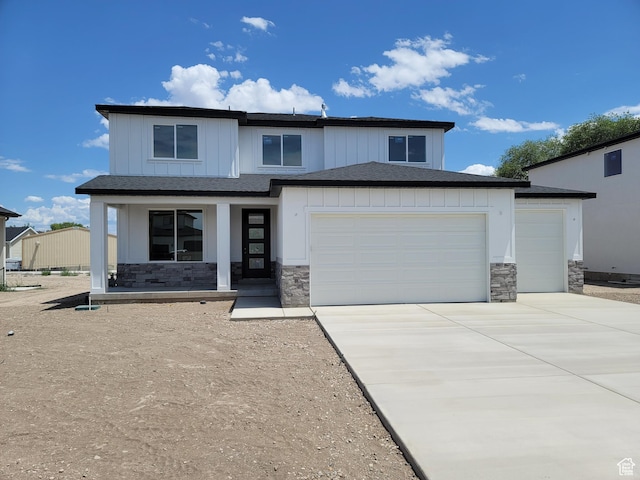 2909 S Richards View Rd Unit 6, Magna, UT 84044 - view of front of house with stone siding, a porch, an attached garage, driveway, and board and batten siding