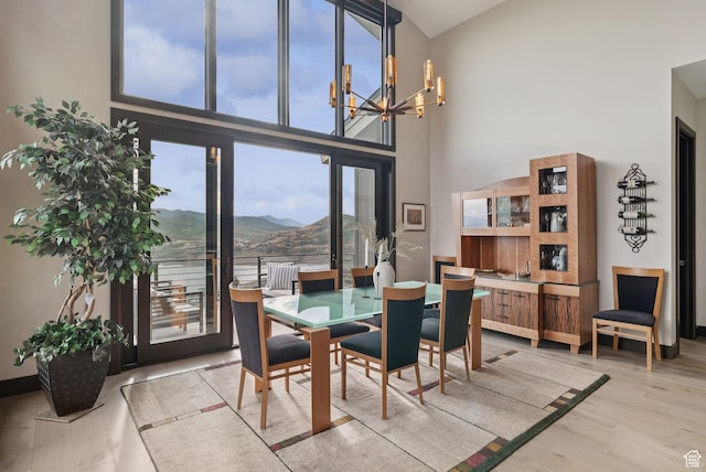 11411 N White Tail Ct, Hideout, UT 84036 - dining room featuring a chandelier, light wood-style flooring, high vaulted ceiling, and a mountain view