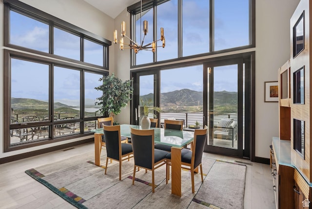 11411 N White Tail Ct, Hideout, UT 84036 - dining area featuring a mountain view, light wood finished floors, a chandelier, and a towering ceiling