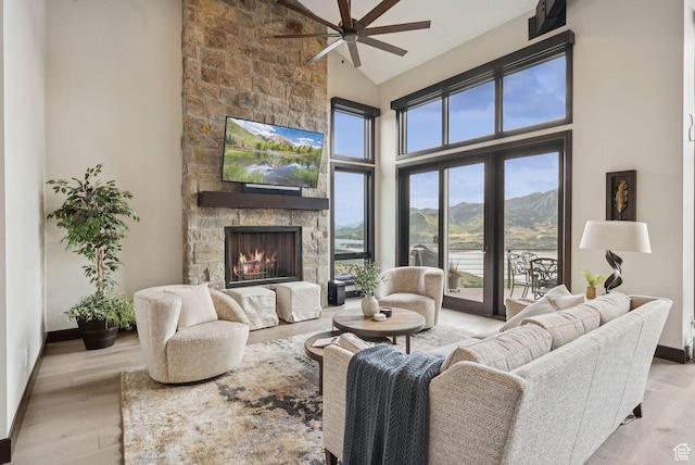 11411 N White Tail Ct, Hideout, UT 84036 - living room featuring ceiling fan, high vaulted ceiling, a stone fireplace, and wood finished floors