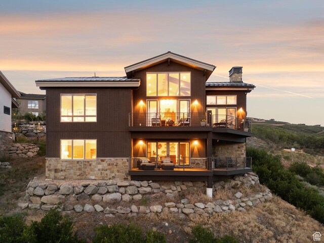 11411 N White Tail Ct, Hideout, UT 84036 - rear view of property featuring a balcony, stone siding, a chimney, and a metal roof