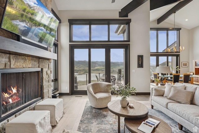 11411 N White Tail Ct, Hideout, UT 84036 - living area featuring wood finished floors, beamed ceiling, high vaulted ceiling, a stone fireplace, and a chandelier