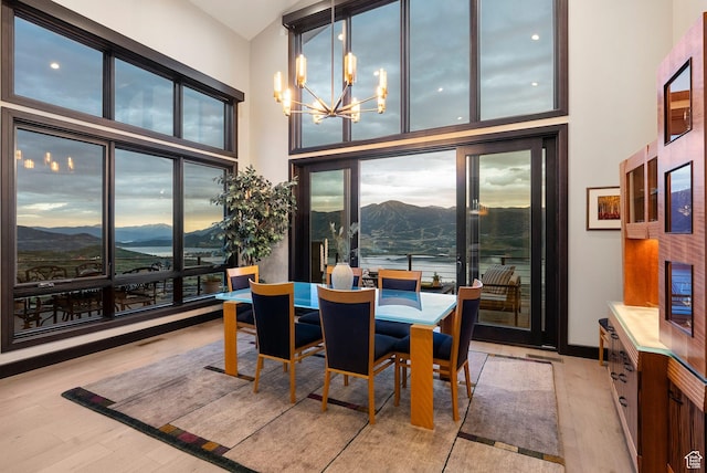 11411 N White Tail Ct, Hideout, UT 84036 - dining room with a chandelier, a mountain view, light wood-style flooring, plenty of natural light, and a high ceiling