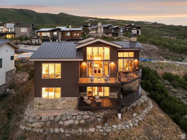 11411 N White Tail Ct, Hideout, UT 84036 - rear view of property with stone siding, a balcony, a metal roof, a chimney, and a standing seam roof