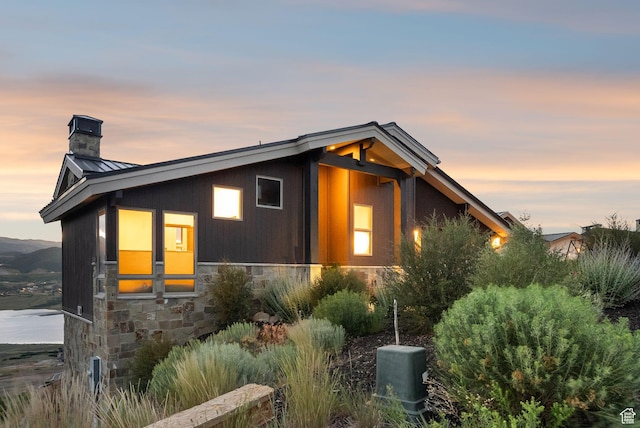 11411 N White Tail Ct, Hideout, UT 84036 - view of property exterior with a chimney, a standing seam roof, stone siding, and a metal roof