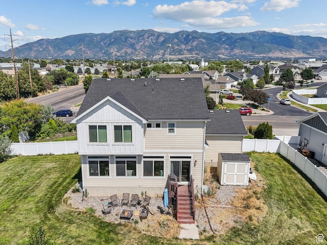 979 N Cold Creek Way, Layton, UT 84041 - back of house featuring a storage unit, board and batten siding, a fenced backyard, a mountain view, and roof with shingles