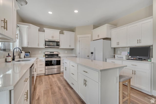 342 W Royal Land Dr, Santaquin, UT 84655 - kitchen featuring appliances with stainless steel finishes, a center island, light wood-style floors, white cabinetry, and recessed lighting
