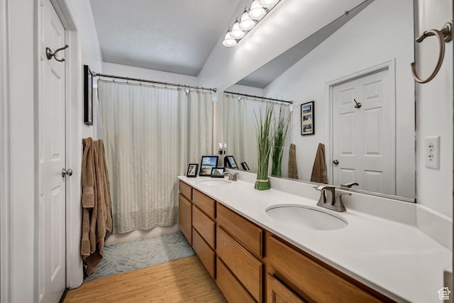 9078 S Harkness Dr W, West Jordan, UT 84088 - bathroom featuring double vanity, wood finished floors, and vaulted ceiling