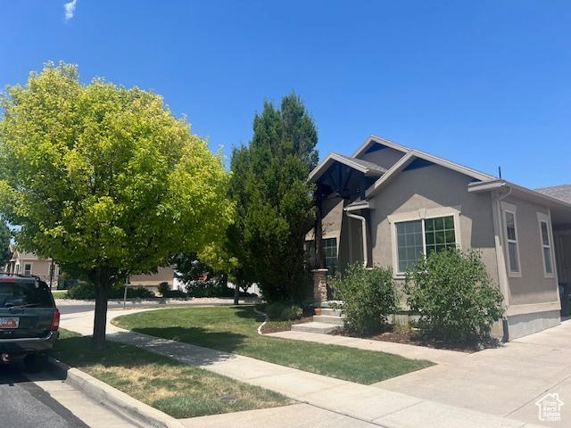 5298 W Icehouse Way, West Jordan, UT 84081 - view of property exterior with stucco siding and a yard