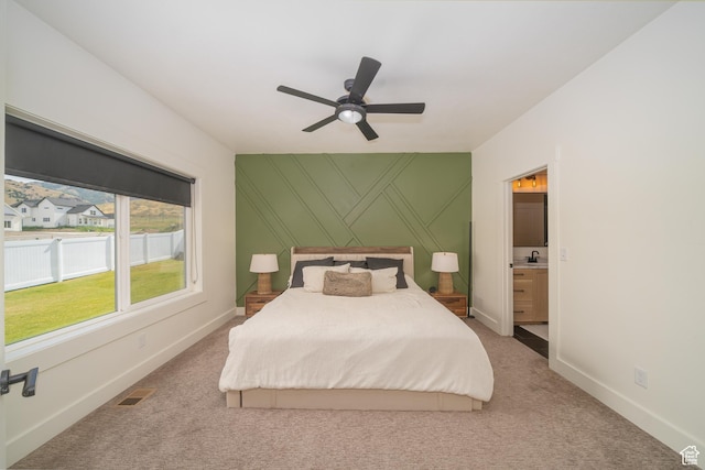 142 N 1100 E, Hyde Park, UT 84318 - bedroom with light colored carpet, ensuite bathroom, ceiling fan, and a decorative wall