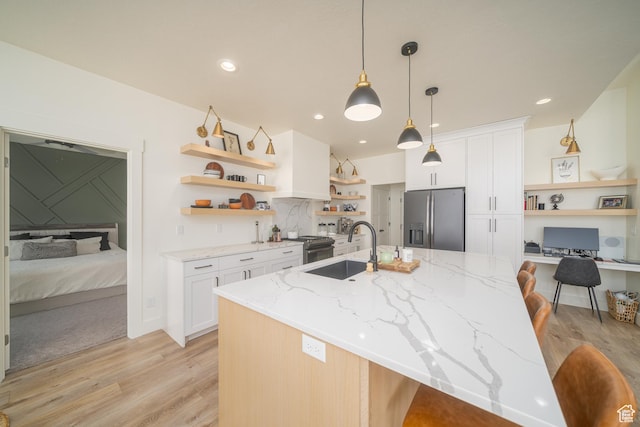 142 N 1100 E, Hyde Park, UT 84318 - kitchen with stainless steel fridge, open shelves, light wood-type flooring, white cabinetry, and a kitchen breakfast bar
