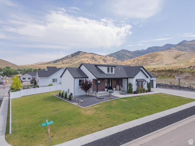 142 N 1100 E, Hyde Park, UT 84318 - modern farmhouse style home with a mountain view, driveway, a porch, and a garage