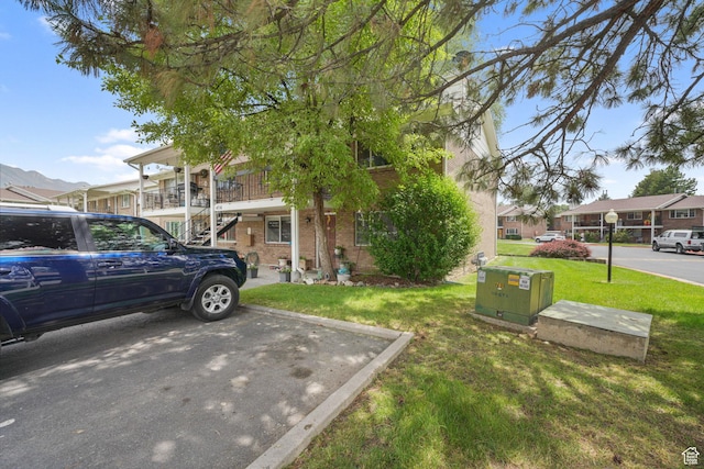 4716 S 700 E Unit 33, Murray, UT 84107 - view of front of property featuring a front lawn, brick siding, stairway, a residential view, and uncovered parking