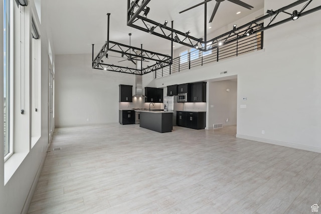 2628 E 40 N Unit 9, Spanish Fork, UT 84660 - unfurnished living room with a towering ceiling, light wood-style floors, a ceiling fan, and healthy amount of natural light