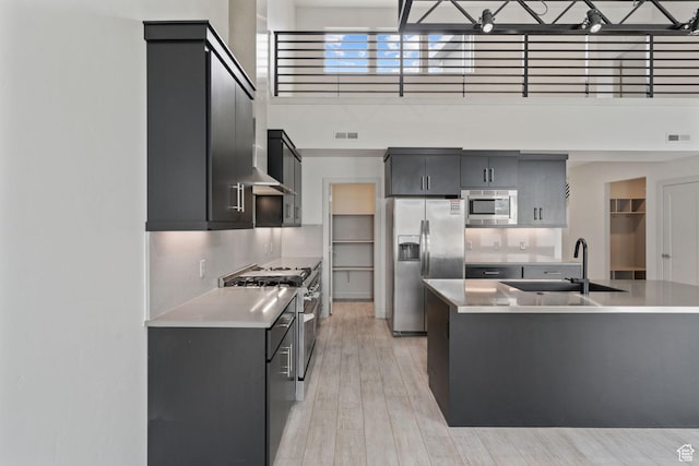 2628 E 40 N Unit 9, Spanish Fork, UT 84660 - kitchen with stainless steel appliances, light countertops, a towering ceiling, light wood finished floors, and dark cabinets
