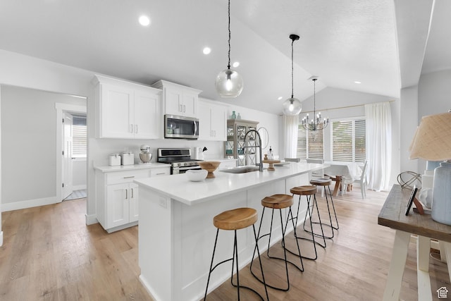 693 S 860 E, Spanish Fork, UT 84660 - kitchen with appliances with stainless steel finishes, lofted ceiling, an island with sink, light countertops, and white cabinetry