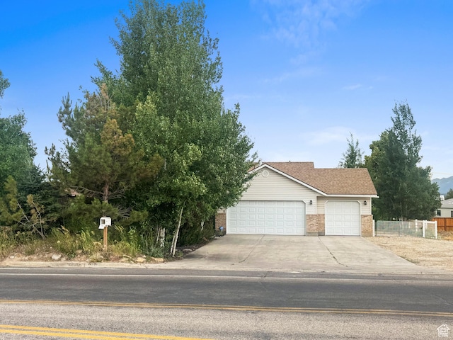325 W Burgi Ln, Midway, UT 84049 - obstructed view of property with brick siding, a garage, and concrete driveway