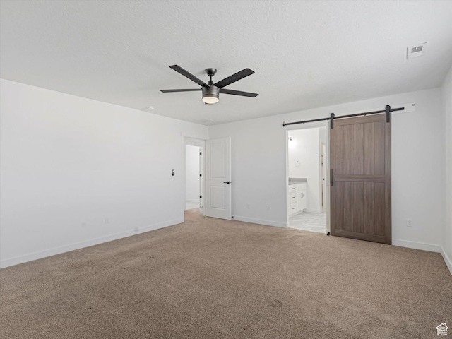 1907 E Brooklyn Cir N, Saratoga Springs, UT 84045 - unfurnished bedroom with a barn door, light colored carpet, ensuite bathroom, and ceiling fan
