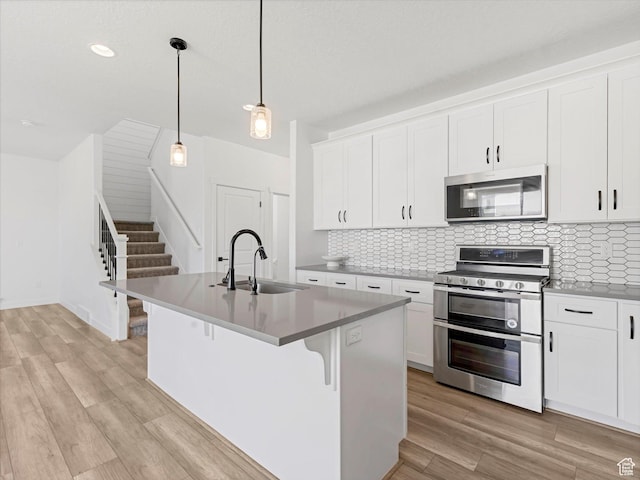 1907 E Brooklyn Cir N, Saratoga Springs, UT 84045 - kitchen featuring appliances with stainless steel finishes, light wood-type flooring, tasteful backsplash, white cabinetry, and recessed lighting