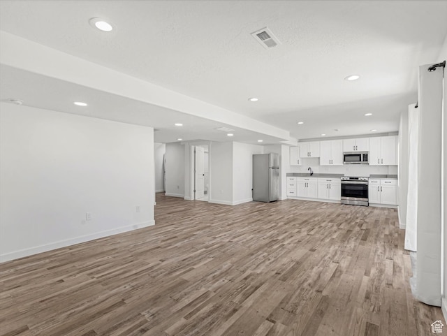 1907 E Brooklyn Cir N, Saratoga Springs, UT 84045 - unfurnished living room featuring light wood finished floors and recessed lighting