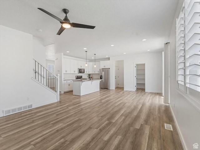 1907 E Brooklyn Cir N, Saratoga Springs, UT 84045 - unfurnished living room with a ceiling fan, light wood-type flooring, recessed lighting, and stairs