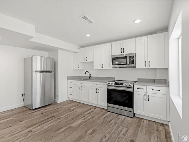 1907 E Brooklyn Cir N, Saratoga Springs, UT 84045 - kitchen with stainless steel appliances, light wood-style floors, white cabinets, light countertops, and recessed lighting