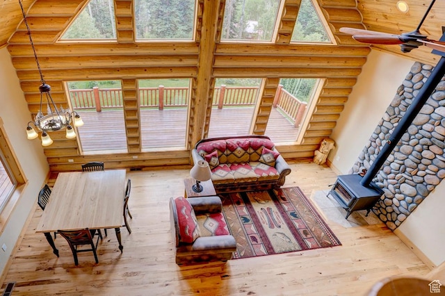 556 N Half Circle Dr, Brian Head, UT 84719 - living area with rustic walls, a wood stove, hardwood / wood-style flooring, a towering ceiling, and a chandelier