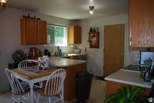 10642 S 1090 E, Sandy, UT 84094 - kitchen with brown cabinetry, light countertops, and a peninsula