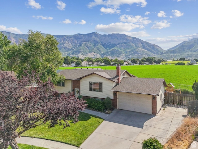 694 E 2350 N, North Ogden, UT 84414 - view of front facade featuring an attached garage, concrete driveway, a mountain view, and brick siding
