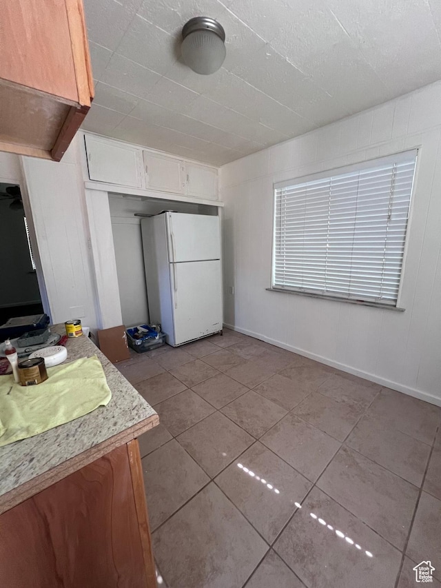 495 E Center St, Pleasant Grove, UT 84062 - kitchen with freestanding refrigerator, tile patterned flooring, white cabinetry, and light countertops