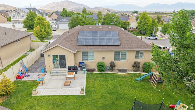 645 Stonebrook Ln, Santaquin, UT 84655 - back of house with a shingled roof, roof mounted solar panels, a fenced backyard, a patio, and stucco siding