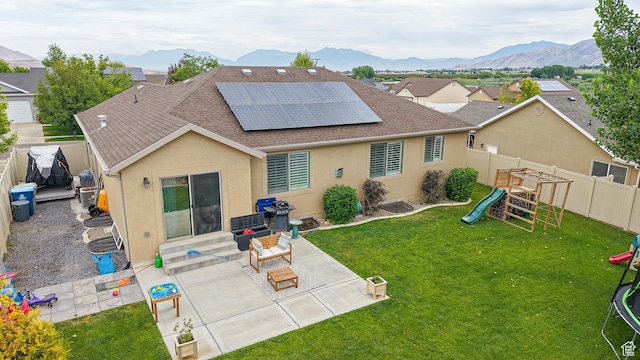 645 Stonebrook Ln, Santaquin, UT 84655 - back of property featuring a playground, roof with shingles, solar panels, a fenced backyard, and a mountain view