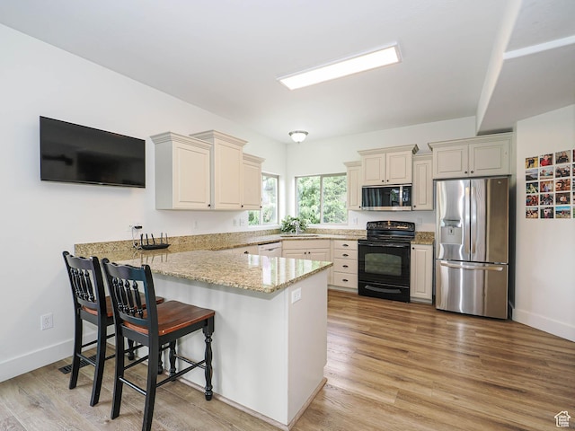 373 N Willow Haven Ave, Lehi, UT 84043 - kitchen with appliances with stainless steel finishes, a peninsula, light stone counters, and light wood finished floors