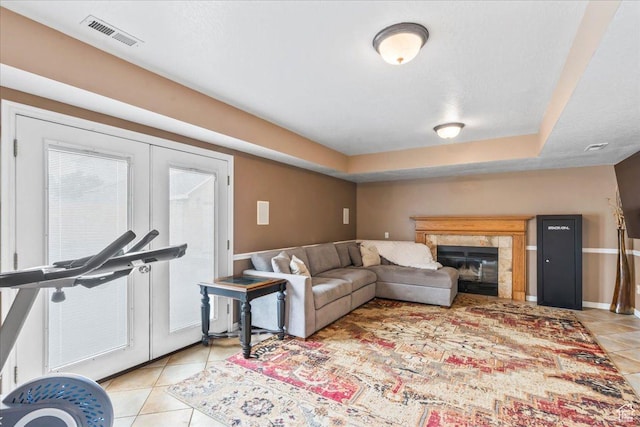 6956 S Firefox Cir, West Jordan, UT 84084 - living room featuring light tile patterned flooring, french doors, a tiled fireplace, and a tray ceiling