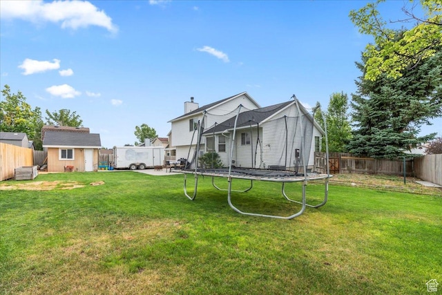 6956 S Firefox Cir, West Jordan, UT 84084 - back of property with a trampoline, a fenced backyard, a storage unit, and a chimney