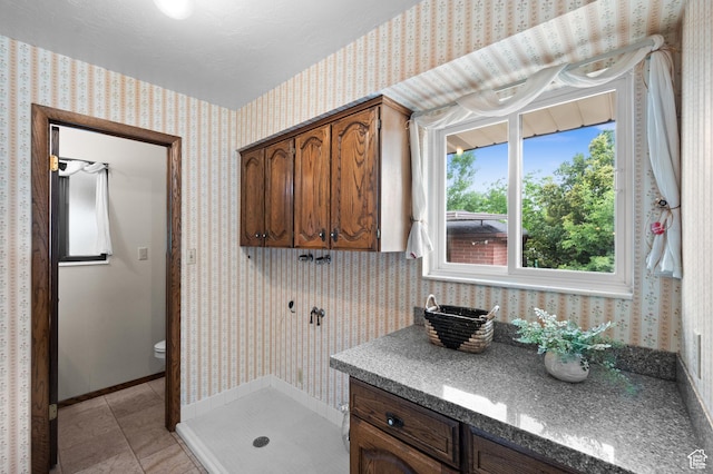 1575 W Alley St, Riverton, UT 84065 - bathroom featuring wallpapered walls, a shower stall, tile patterned floors, and vanity
