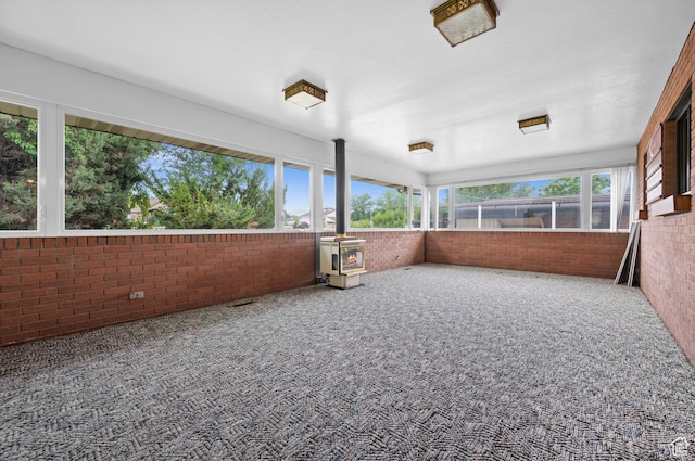 1575 W Alley St, Riverton, UT 84065 - unfurnished sunroom featuring brick wall, a wood stove, and carpet