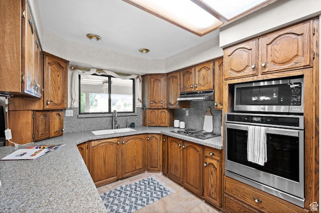1575 W Alley St, Riverton, UT 84065 - kitchen featuring stainless steel appliances, decorative backsplash, brown cabinets, light countertops, and under cabinet range hood