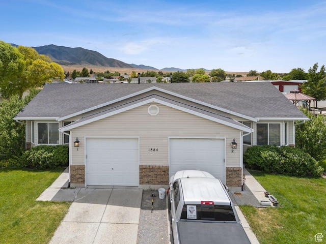 1884 E Shepard Ln, Lake Point, UT 84074 - view of front of property featuring driveway, brick siding, a front yard, and a mountain view