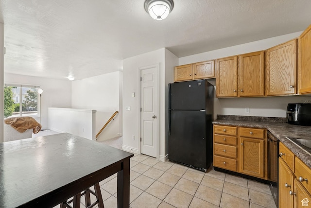 1884 E Shepard Ln, Lake Point, UT 84074 - kitchen with black appliances, dark countertops, light tile patterned floors, and brown cabinetry