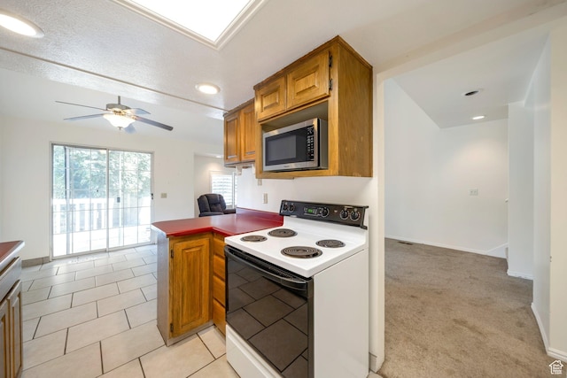 527 Applewood Dr, Bountiful, UT 84010 - kitchen featuring white electric range, stainless steel microwave, brown cabinets, ceiling fan, and a peninsula