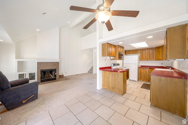 527 Applewood Dr, Bountiful, UT 84010 - kitchen featuring white appliances, light tile patterned flooring, light carpet, ceiling fan, and a tile fireplace