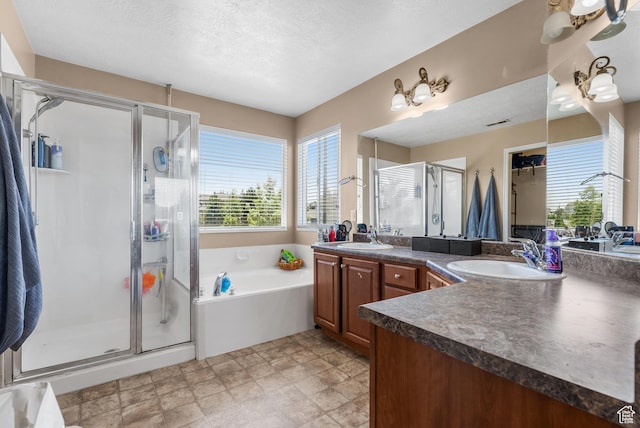 5453 W Mayflower St, West Jordan, UT 84081 - bathroom featuring vanity, a shower stall, a garden tub, a textured ceiling, and stone finish floors