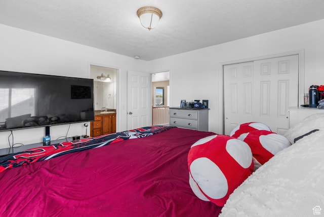 5453 W Mayflower St, West Jordan, UT 84081 - bedroom featuring a closet, ensuite bathroom, and a textured ceiling