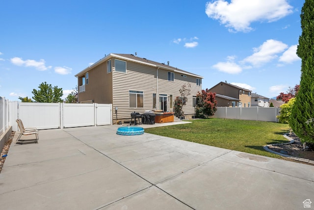 5453 W Mayflower St, West Jordan, UT 84081 - back of property featuring a patio area, a hot tub, and a fenced backyard