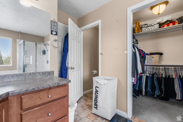 5453 W Mayflower St, West Jordan, UT 84081 - full bathroom with vanity, a stall shower, a spacious closet, and a textured ceiling